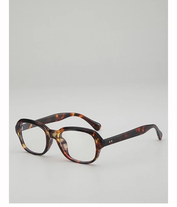 Détail de lunettes de soleil écaille de tortue avec rivets argentés et texture ambre