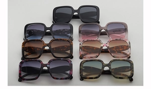 Flat lay collection of oversized square sunglasses in various colors and patterns
