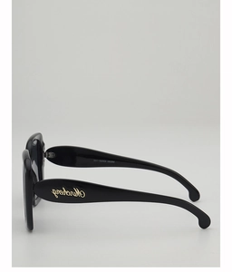 Detail view of black wide-frame sunglasses featuring a golden logo on temples