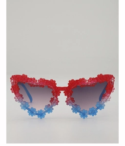 Detailed shot of heart-shaped kids sunglasses with red and blue daisy flower decorations