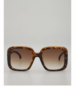 Close-up of tortoise shell oversized sunglasses with brown gradient lenses and glossy finish