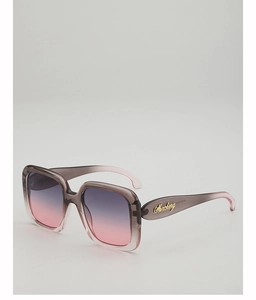 Detail view of the golden Marcheng logo on grey-pink gradient oversized sun glasses