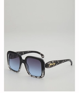 Detail of oversized square sunglasses featuring tortoiseshell temples and golden logo