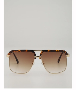 Close-up of tortoise shell and gold metal frame sunglasses with brown gradient lenses