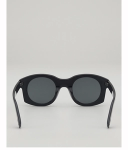 Détail de la monture noire brillante et des branches épaisses des lunettes de soleil rétro