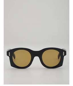 Détail de lunettes de soleil œil-de-chat vintage avec monture noire et verres ambre