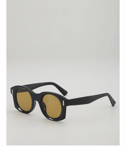 Détail de lunettes de soleil œil-de-chat rétro avec monture noire et verres jaunes
