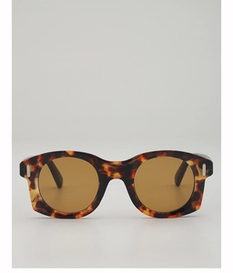 Détail de lunettes de soleil vintage œil-de-chat avec monture écaille épaisse et verres marron