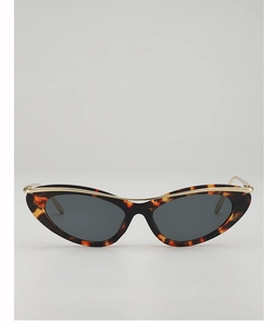 Detail of tortoiseshell cat-eye sunglasses featuring a stylish gold metal top bar accent