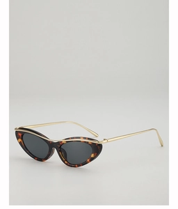 Detail of tortoiseshell cat eye sunglasses with gold metal top bar and dark grey lenses