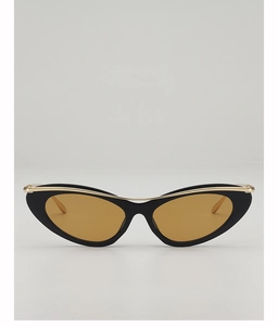 Detail of cat eye sunglasses featuring a black frame with gold metal top bar and amber lenses