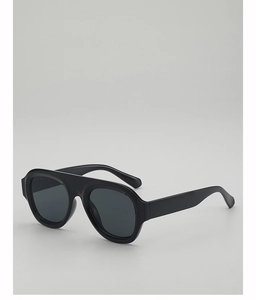 Detail of black pilot-style sunglasses with thick frames and dark grey lenses