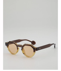 Detail of octagonal two-tone sunglasses with brown tortoise and amber frames and metal rivets