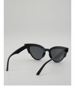 Close-up of black oval sunglasses featuring wide temples and an upswept cat-eye frame