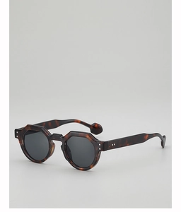 Detail view of tortoiseshell geometric sunglasses frames with dark grey polarized lenses