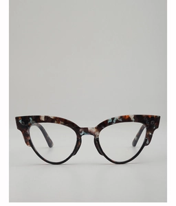 Detailed view of cat-eye sunglasses with tortoiseshell patterns and silver cross ornaments
