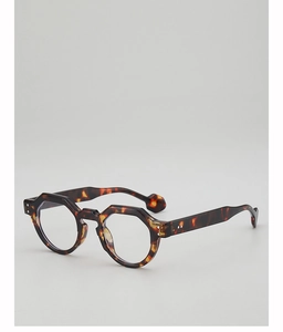 Close-up of tortoise shell geometric sunglasses featuring silver rivets and ball tips
