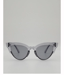 Macro detail of oval sunglasses featuring a chic transparent grey frame and dark lenses