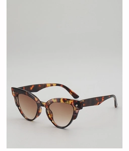 Detail view of tortoiseshell cat-eye sunglasses with brown gradient lenses and metal rivets