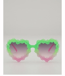 Detail shot of heart-shaped sunglasses featuring gradient green-pink floral frame and lenses