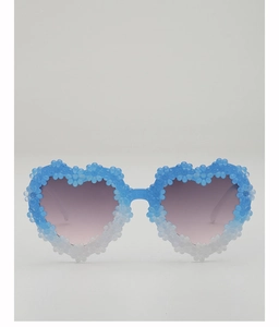 Detail of heart-shaped sunglasses with floral accents and blue to white gradient frame