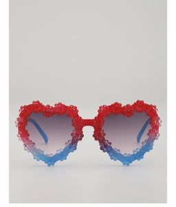 Detail shot of heart-shaped kids sunglasses with red-blue gradient and floral 3D decor