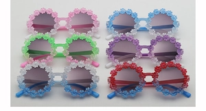Close-up of kids daisy flower sunglasses in pink, blue, green, and purple colors