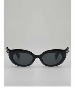 Detail of black cat-eye sunglasses with silver curved accents and studded decorations