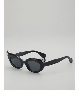 Close-up of black cat-eye sunglasses featuring unique horn accents and metal studs