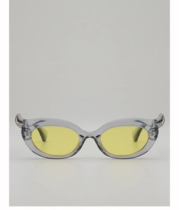 Detail of transparent grey cat-eye sunglasses with yellow lenses and silver horn accents