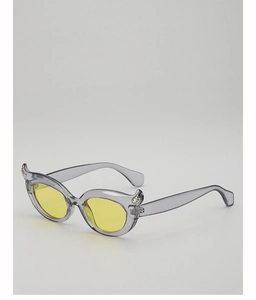 Detail of horn-style cat eye sunglasses with grey frames and yellow tinted lenses