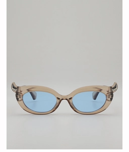 Close-up of translucent brown cat-eye sunglasses with silver horn accents and blue lenses