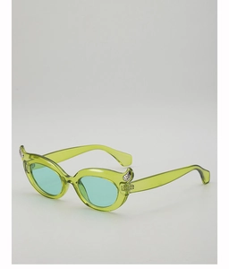 Detail view of translucent green cat eye sunglasses with silver heart accents in Y2K style