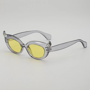 Cat-eye sunglasses with yellow lenses and grey translucent frames in a side view