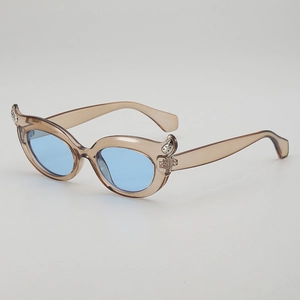 Cat eye sunglasses with light brown resin frame, blue lenses and silver wing accents