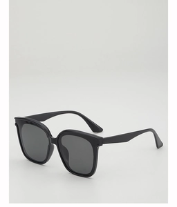 Detail view of large square black frame sunglasses with deep grey lenses for UV protection