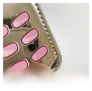 Macro detail of silver mirror handbag featuring pink plush embroidered numeric buttons