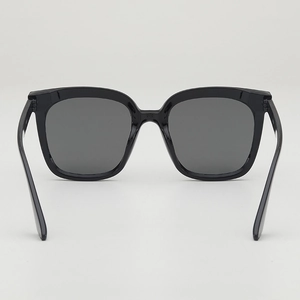 Classic black oversized sunglasses with dark grey lenses for UV protection on white background