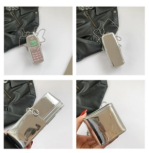 Macro view of silver mirror mini bag featuring vintage mobile phone design and chain strap