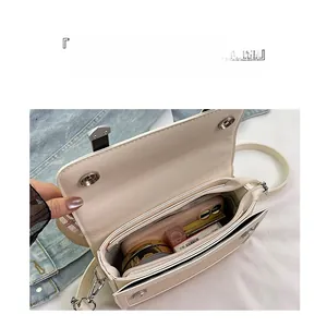 Top view of cream leather crossbody bag showing internal compartments and storage capacity