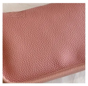 Detail of high-quality pink lychee grain leather with soft texture on a shoulder bag