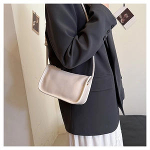 Chic beige lychee leather crossbody bag for women styled with casual autumn business attire