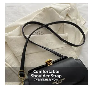 Close-up of black leather box bag featuring gold metal push-lock and fashion brand logo