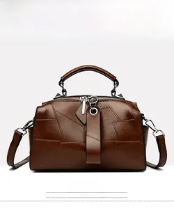 Detailed front view of brown textured leather handbag with metal ring and patchwork design