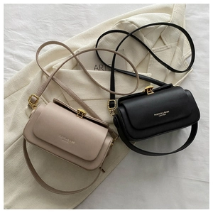 Detail of elegant black and beige crossbody box bags with gold metal clasps