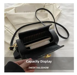 Top view of black cylinder bag interior showing capacity for phone and wallet with stripe lining