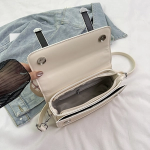 Off-white leather underarm bag with interior zip pocket and dual magnetic buckles