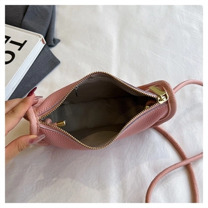 Pink lychee grain leather crossbody bag with golden zipper and spacious main compartment