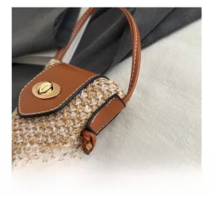 Detail shot of woven straw bag with leather trim and gold twist-lock closure