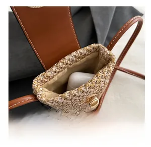 Macro view showing the interior capacity and straw texture of the mini crossbody bag